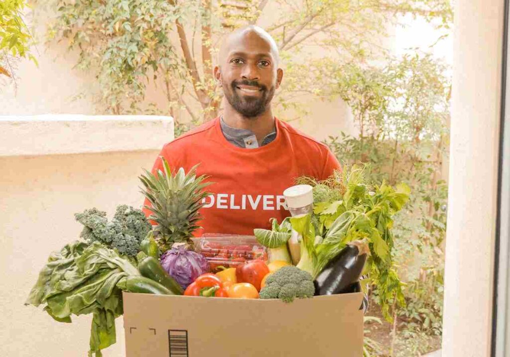 man carrying grocery box at Coles store reflecting trading hours for Coles