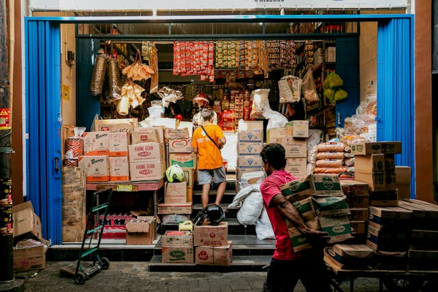men carrying cartons into supermarket emphasising trading hours for Coles